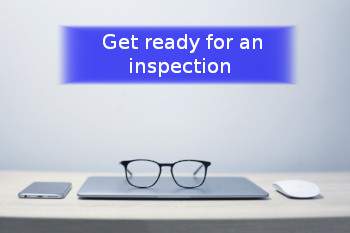 a pair of glasses on a mouse mat , a mouse and a smartphone with banner stating Are you ready for an inspection?