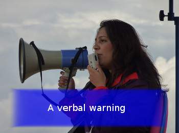 person with megaphone and banner stating A verbal warning